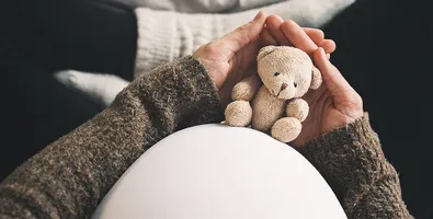 A person holding a flower representing pregnancy loss remembrance