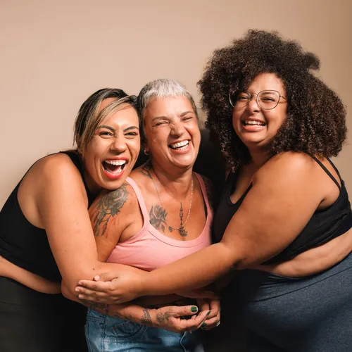 Three women laughing and hugging