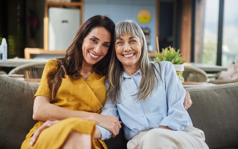 two women sat on a couch