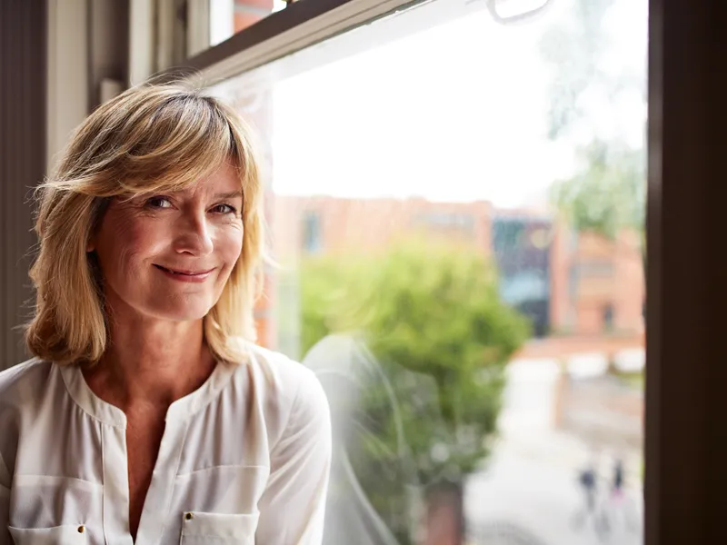 woman smiling next to window